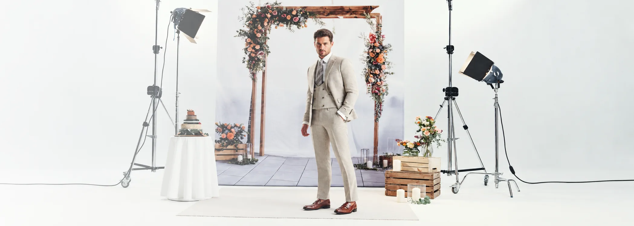 A groom in a fitted three-piece suit on a styled wedding set